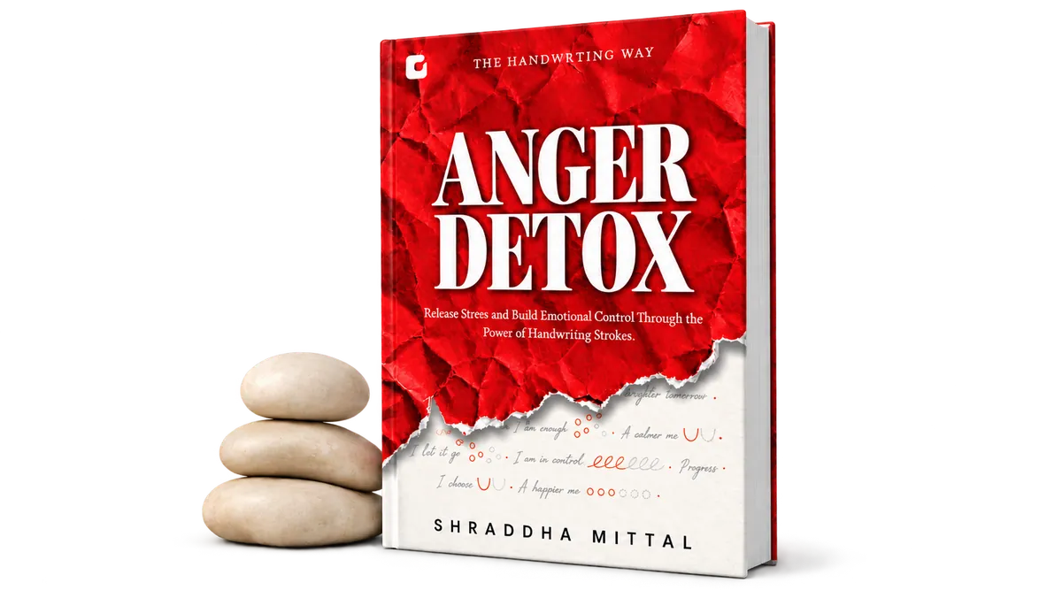 Anger Detox hardcover beside a stack of smooth stones